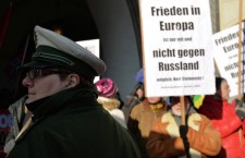 Полицейский на многотысячной демонстрации на площади у городской ратуши в Мюнхене с лозунгами прекратить конфронтацию с Россией